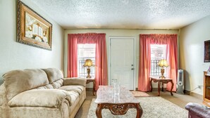 Un salon avec un canapé beige, une table basse en bois et deux lampes placées sur des tables d’appoint assorties.