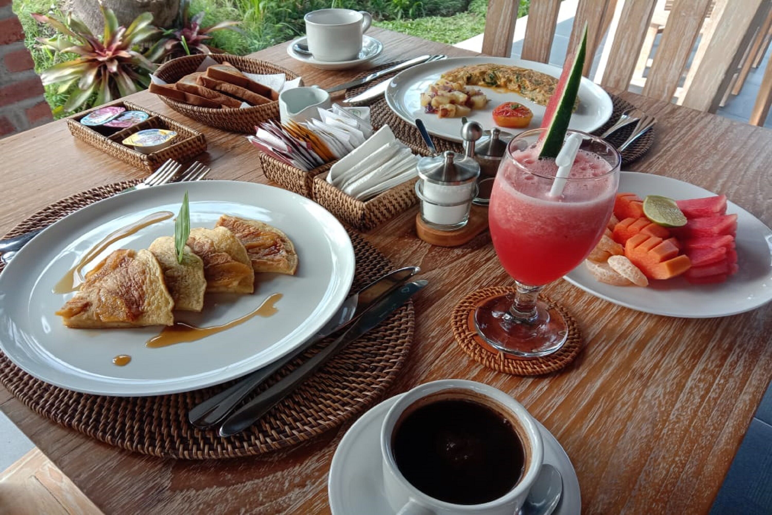 Et morgenbord med tallerkener med mad, drikke og tilbehør.