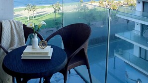 Ein Balkon mit Blick auf den Ozean und einen Golfplatz.