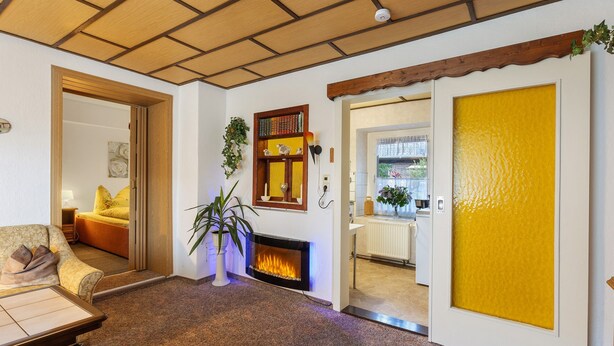 A cozy living room with a fireplace, a sofa, and a dining table.