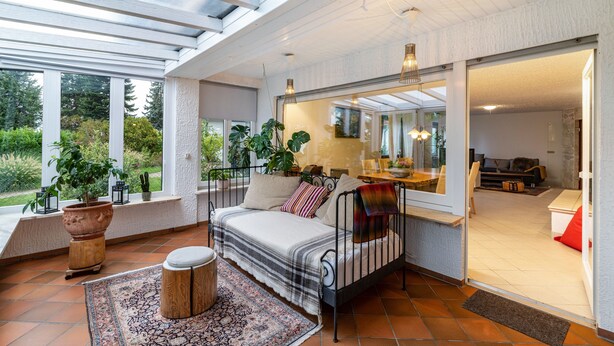 A sunlit room with a bed, a large window, and a view of greenery outside. - Apartment 'Schwarzwald Glück Ferienwohnung' with Private Terrace and Wi-Fi (Bühl)