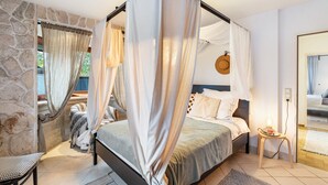 A bedroom with a four-poster bed, a stone wall, and a view of the outdoors. - Apartment 'Schwarzwald Glück Ferienwohnung' with Private Terrace and Wi-Fi (Bühl)