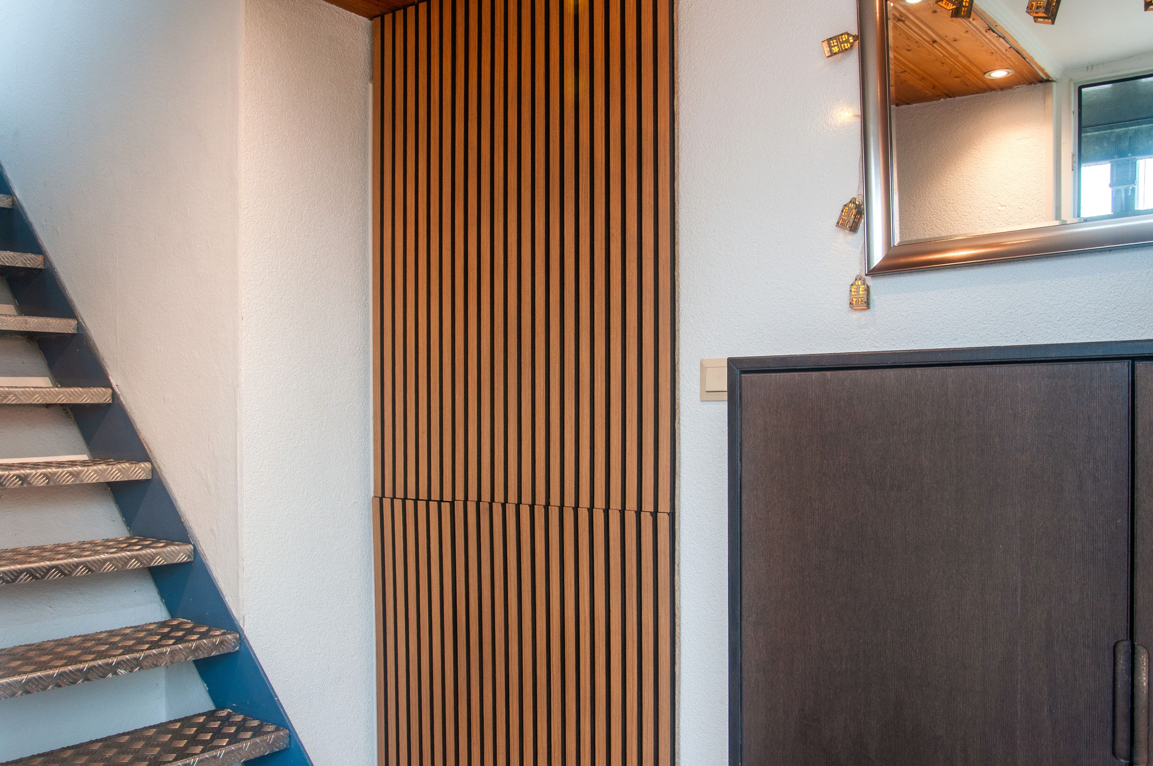Una escalera con una pared con textura y una puerta oscura.
