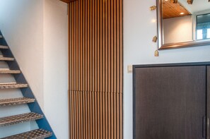 A staircase with a textured wall and a dark door. - Gallery Apartment with Lake View, Balcony, and Wi-Fi (Absberg)