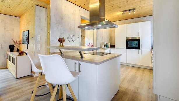 A modern kitchen with a central island, white cabinetry, and a stainless steel range hood. - Holiday Home for up to 6 Guests with Pool and Sauna (Freudenstadt)