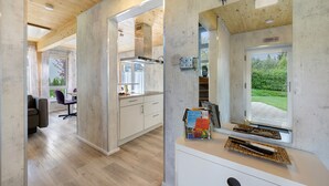 Een modern interieur met een keuken, eethoek en een raam met uitzicht op groen.