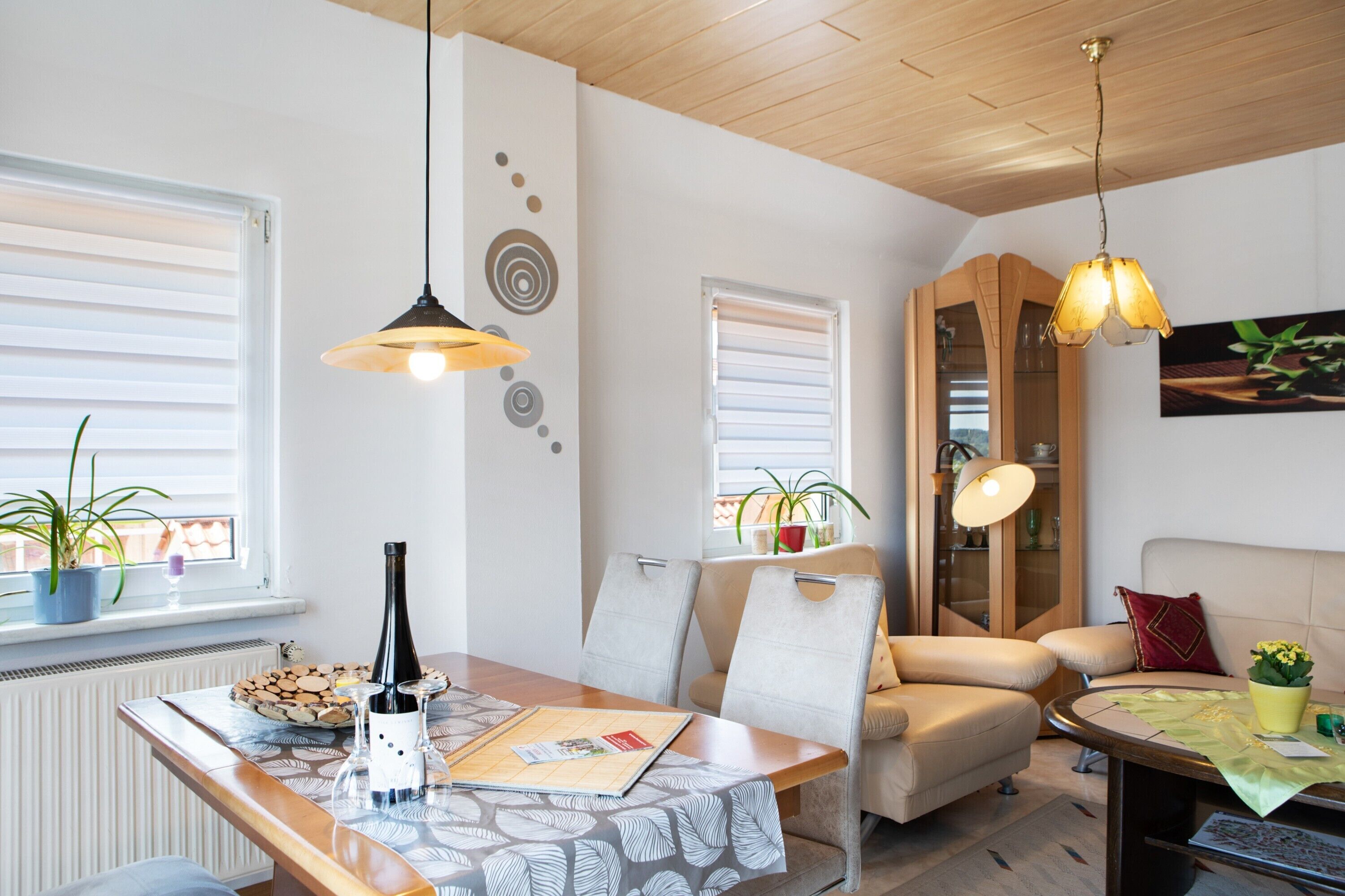 Un salon moderne comprenant une table à manger, des chaises, un canapé et un meuble.