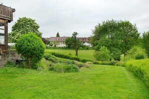 Un quartier résidentiel avec une pelouse verdoyante, un arbre et un bâtiment à ossature en bois.