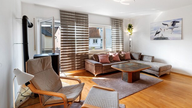 A modern living room with a sofa, chairs, a coffee table, and a TV.