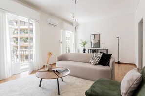 Ein modernes Wohnzimmer mit einer Couch, einem Couchtisch und einer Stehlampe.