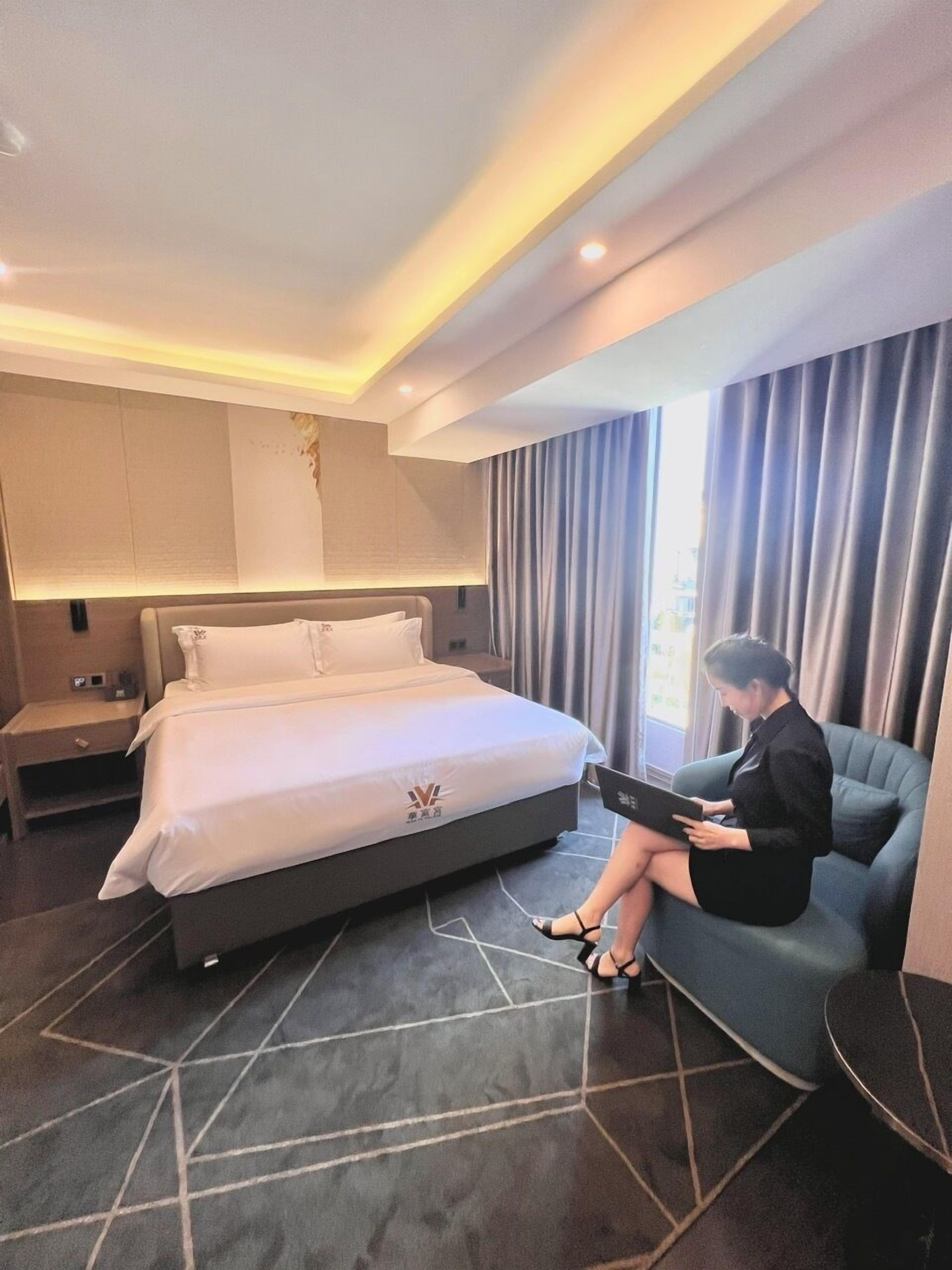 Une chambre d’hôtel moderne dotée d’un grand lit, d’un bureau et d’un coin salon.