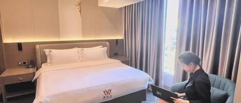 Une chambre d’hôtel moderne dotée d’un grand lit, d’un bureau et d’un coin salon.