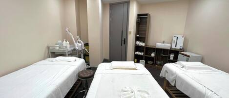 Une chambre d’hôtel avec deux lits, une petite table avec des articles de toilette, un miroir et une armoire.
