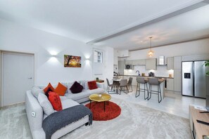 Un apartament modern amb saló, cuina i zona de dinar.