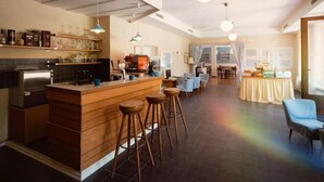 Una cocina moderna con una isla central, taburetes de bar y un comedor con sillas y una mesa.