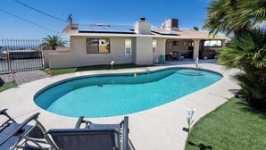 Una proprietà residenziale con piscina, pannelli solari e giardino recintato.