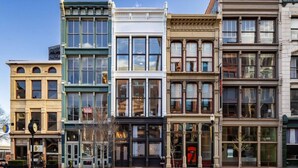 Una hilera de edificios de varios pisos con grandes ventanales y diferentes estilos arquitectónicos.