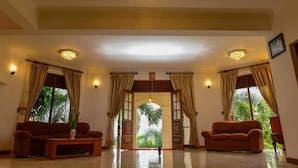 A spacious lobby with two sofas, a coffee table, and a chandelier. - Siyonra Bungalow  (Thotagamuwa)