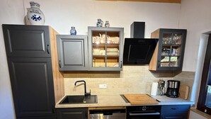 Une cuisine moderne équipée d’un lave-vaisselle, d’un four et d’un meuble avec des portes en verre.