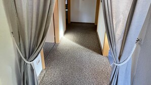 Une pièce dont le sol est recouvert d’une moquette, dont le plafond est en bois et qui est équipée d’un luminaire.