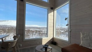 A room with large windows offering a view of a snowy landscape.