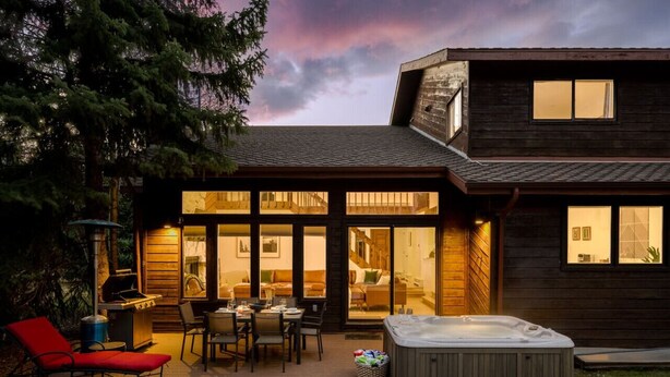 Une maison moderne dotée d’un patio, d’un jacuzzi et d’un barbecue.