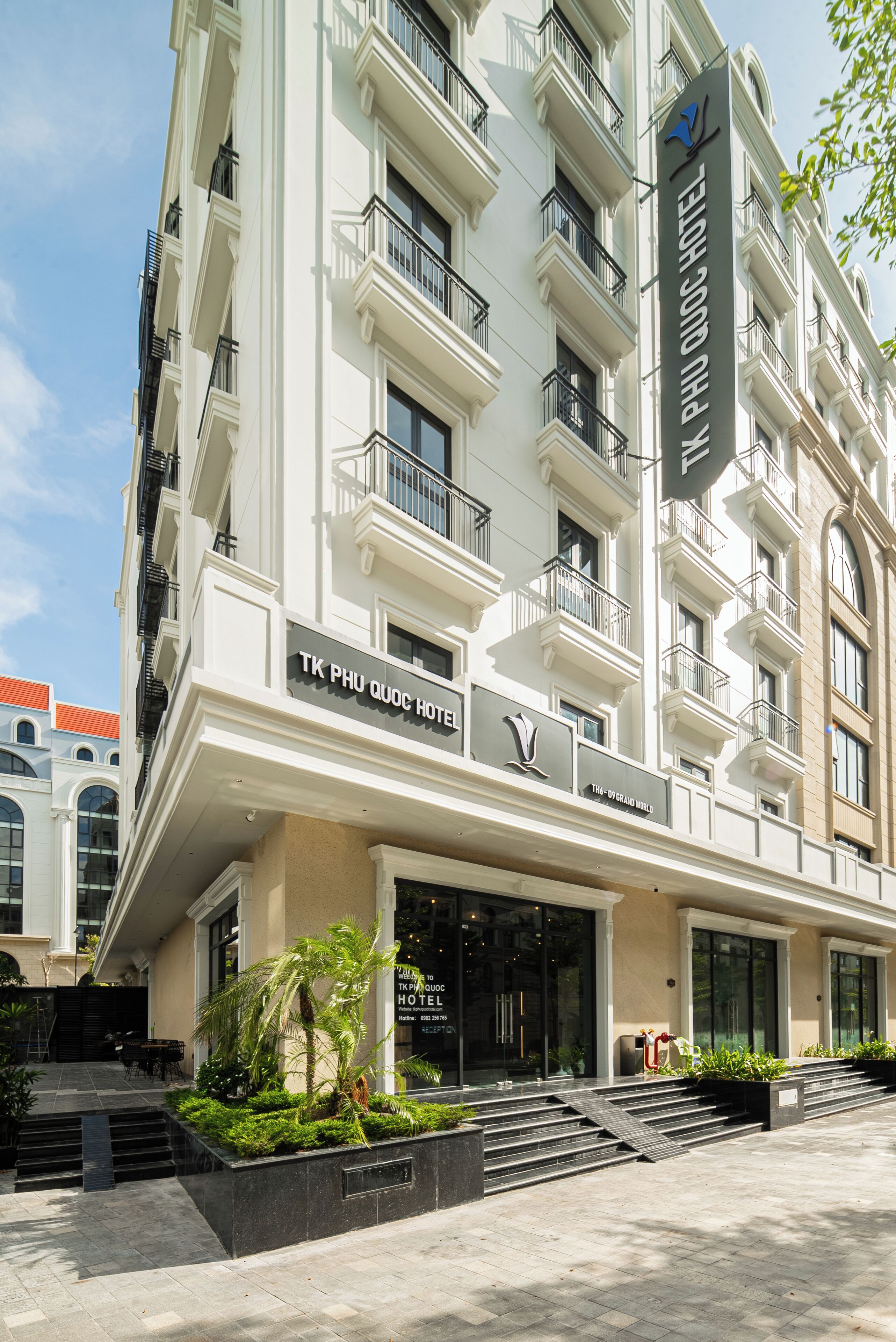 Ein mehrstöckiges Hotel mit klassischer Architektur, mit Balkonen und einem markanten Eingang, der über Stufen zu den Türen führt.