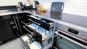 A modern kitchen with built-in appliances, including a dishwasher, oven, and coffee maker. - Exklusives City Apartment Nature (Leipzig)