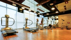 A gym with treadmills, elliptical machines, and stationary bikes. - Sway Suites (Manama)