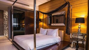 A modern bedroom with a four-poster bed, a glass partition, and a wooden wall. - Sway Suites (Manama)