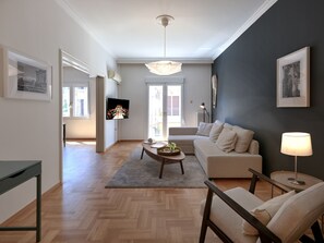 A modern living room with a sofa, coffee table, and a TV mounted on the wall.
