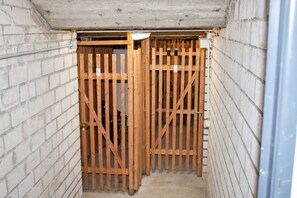 A narrow, enclosed space with a wooden gate and brick walls, likely a utility or service area. - Schöne Ferienwohnung mit Balkon Direkt am Erlebinsberg Kappe (Winterberg)