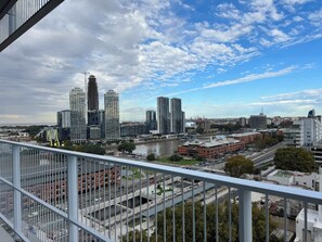Une vue urbaine avec des immeubles modernes de grande hauteur, une rivière et un pont.