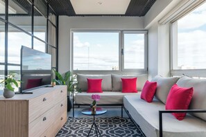 Uma sala de estar moderna com um sofá, uma televisão e uma mesa de centro.