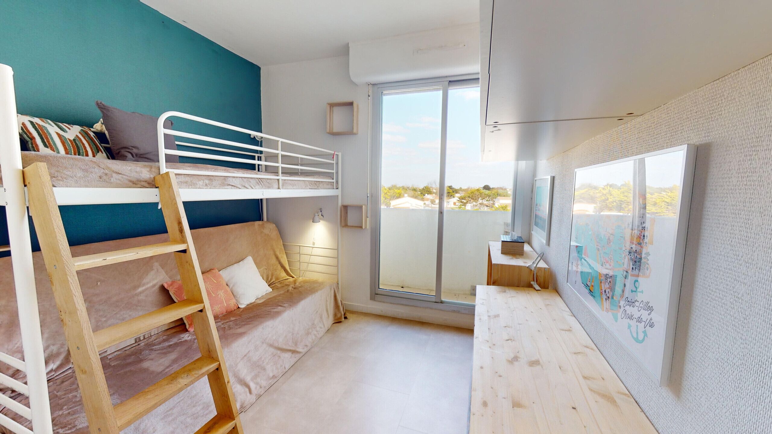 Una habitación con una cama litera, un sofá, un escritorio de madera y un ventanal con vistas.