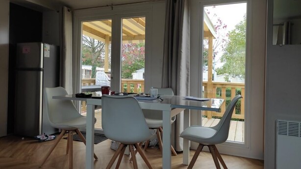 Una cocina moderna con una mesa de comedor y sillas, ventanas amplias y vistas al exterior.