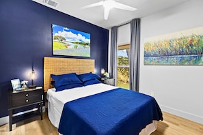 Un dormitorio con cama, mesita de noche y un cuadro en la pared.