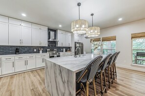 Enjoy cooking in this well-equipped kitchen with a large island, oven, and refrigerator.