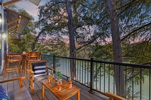 Outdoor dining - Discover modern riverfront luxury at The White House. Enjoy a sleek designer kitchen, a tranquil master suite, and an expansive deck with breathtaking views of the Guadalupe River. Experience the perfect blend of hotel-quality service and the privacy (New Braunfels)
