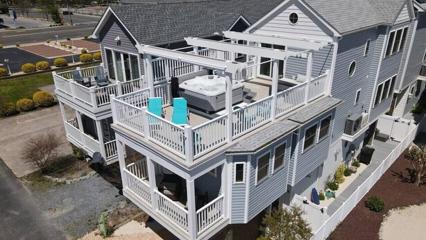 Un edificio de varios pisos con balcones, un jacuzzi y una zona exterior cubierta.