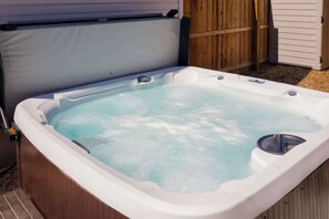 Un jacuzzi con una terraza de madera alrededor.