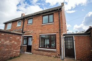 A two-story brick house with a front door, two windows, and a small front yard. - The Lampton - Modern - Gibside - Smart Tv - WIFI (County Durham)