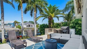 A patio with outdoor furniture, a pool, and palm trees. - Waterfront 3BR/2BA Marco Island home with heated pool, WiFi, and kitchen. (Marco Island)