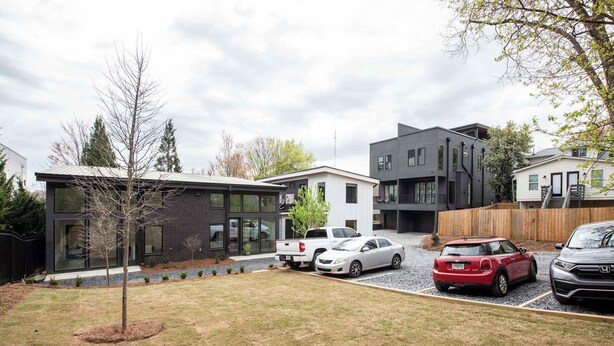 Un quartier résidentiel moderne avec des maisons contemporaines, une allée et des voitures garées.