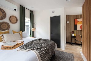 A modern bedroom with a bed, bedside table, and a view of the outside. - Champagne Wishes (Atlanta)