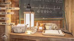 A rustic wooden desk with a chalkboard displaying a welcome message and directions to various local attractions.