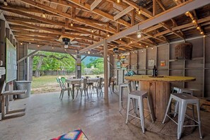 An open-plan space with a wooden ceiling, a bar area, and outdoor seating. - Whiskey Ginger - Wine Barn, Fire Pit & More! (Fredericksburg)