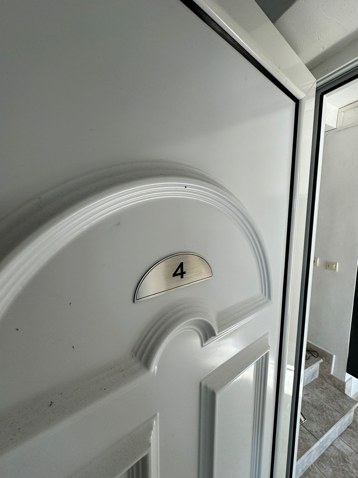 Une porte blanche avec une plaque indiquant le numéro de la chambre : 4.