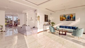 A spacious lobby with a marble floor, a reception desk, a blue sofa, and a dining area with a table and chairs. - Beverly Beach - Negambo (Negombo)