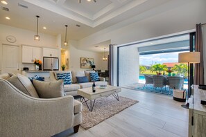 A modern living room with a sofa, coffee table, and a view of the outdoor patio area.